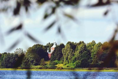 Scenic view of lake by trees against sky