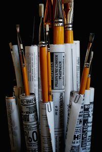 Paintbrushes with papers against black background