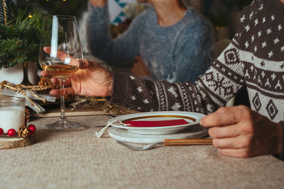 Midsection of woman drinking glasses on table
