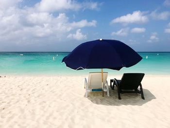 Lifeguard chair on beach against sky