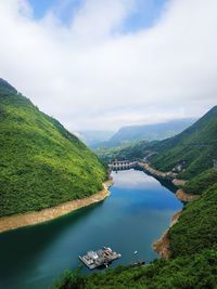 High angle view of river amidst green landscape against sky