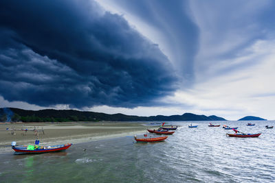 Boats moored in sea against sky