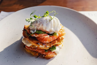 Stack of hash browns with salmon and poached egg on the top. close-up of gourmet breakfast 
