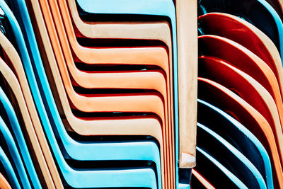 Full frame shot of stacked chairs during sunny day