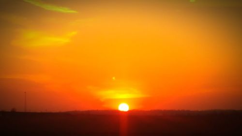 Scenic view of silhouette landscape against orange sky