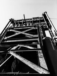 Low angle view of crane in building against sky