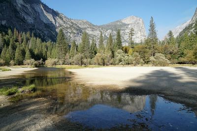 Scenic view of lake by mountains against clear sky