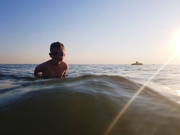 Man swimming in sea against clear sky