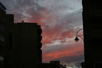 Low angle view of buildings against dramatic sky