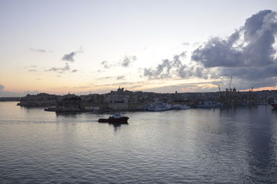 Silhouette of boats in calm sea at sunset