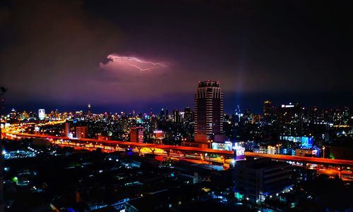 Illuminated city against sky at night