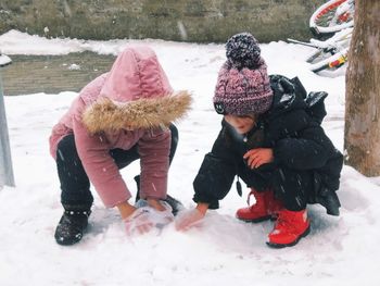 Rear view of children on field during winter