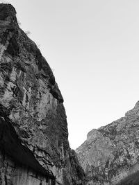 Low angle view of rocky mountains against clear sky