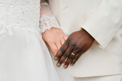 Causian and african couple holding hand with ring