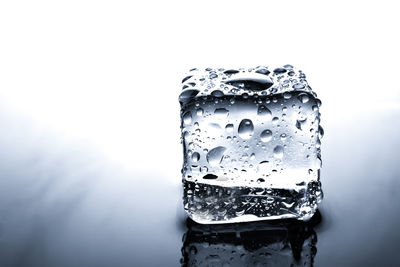 Close-up of wet glass against white background