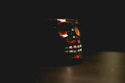 Close-up of illuminated light bulb on table in darkroom