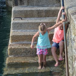 Rear view of girls and girl standing by wall