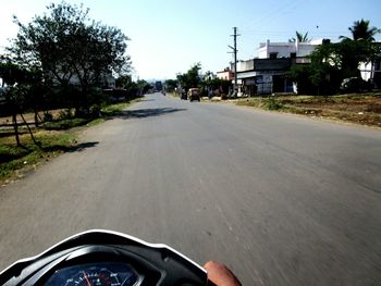 Man on car on street against sky