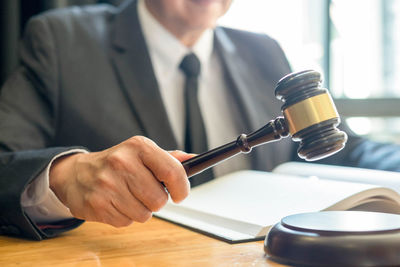 Midsection of man holding camera on table