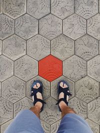 Low section of man standing on tiled floor