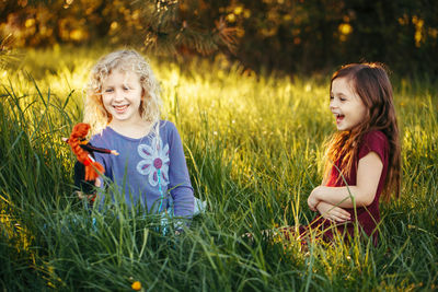 Friends playing with dolls on field