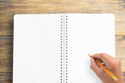 High angle view of human hand on book