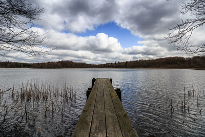 Jetty over lake against sky