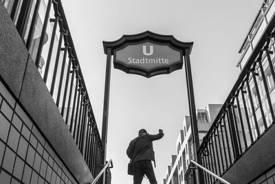 Low angle view of man standing against clear sky in city