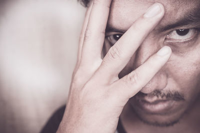 Close-up portrait of angry man with hand touching his face