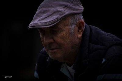 Close-up portrait of man against black background