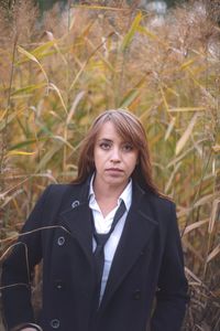 Portrait of woman standing amidst plants