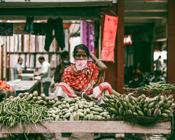 Portrait of boy in basket at market stall