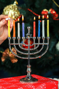 Cropped hand burning candles on menorah