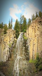 Low angle view of waterfall against sky