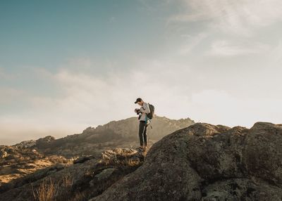 Full length of man standing on rock against sky