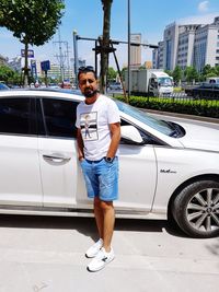 Full length of man standing on car in city