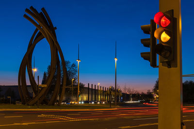 Light trails on road against blue sky