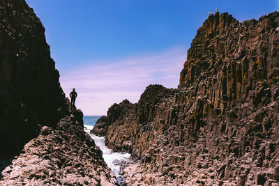 Rock formations by sea against sky