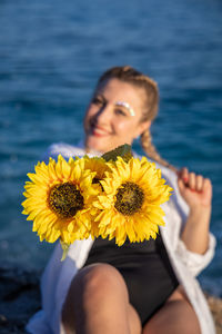 Portrait of smiling woman with yellow flower