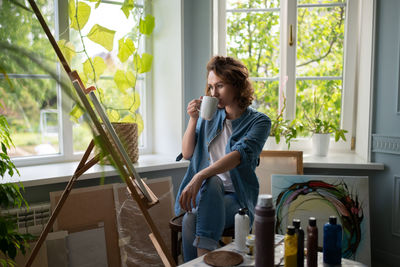 Woman admiring artwork in home studio
