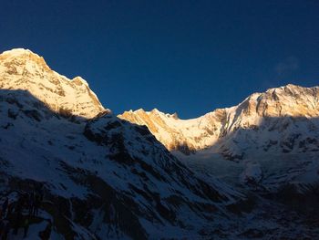 Scenic view of snowcapped mountains against clear sky