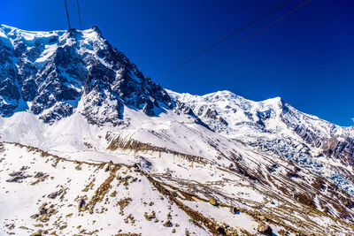 Scenic view of snowcapped mountains against clear blue sky