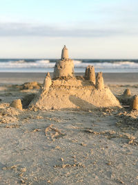 Sandcastle on beach against sky