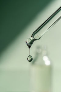 A drop of cosmetic oil falls from the pipette