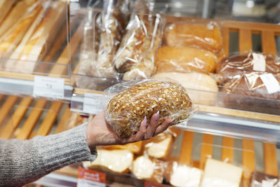 Woman holding loaf of fresh bread in the store