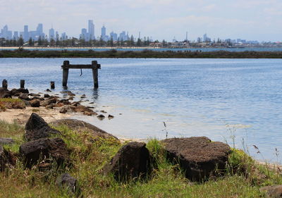 Scenic view of river by city against sky