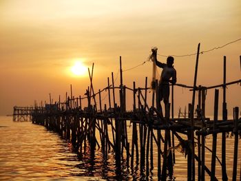 Pier on sea at sunset