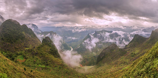 Panoramic view of valley and mountains against sky