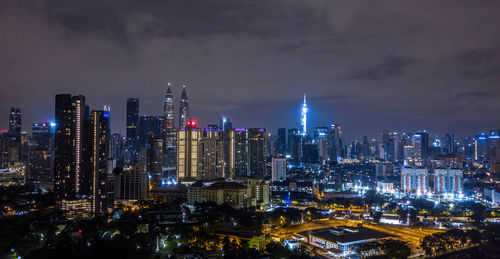 Illuminated cityscape against sky at night