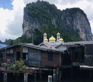 Houses by lake against sky